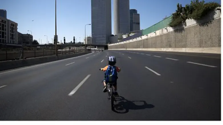 A child rides his bike along a deserted highw