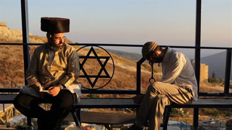 Religious Jews sit near the Ari'zal's tomb, T