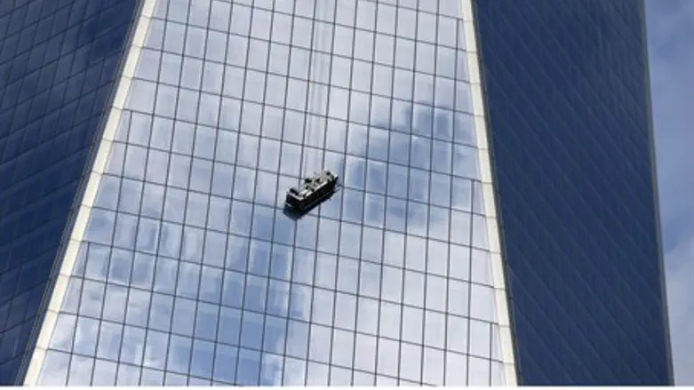 Stranded window washers hang on the side of O