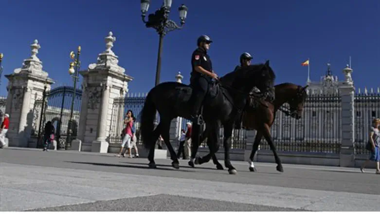 Mounted police officers patrol outside the Royal Palace in Madrid