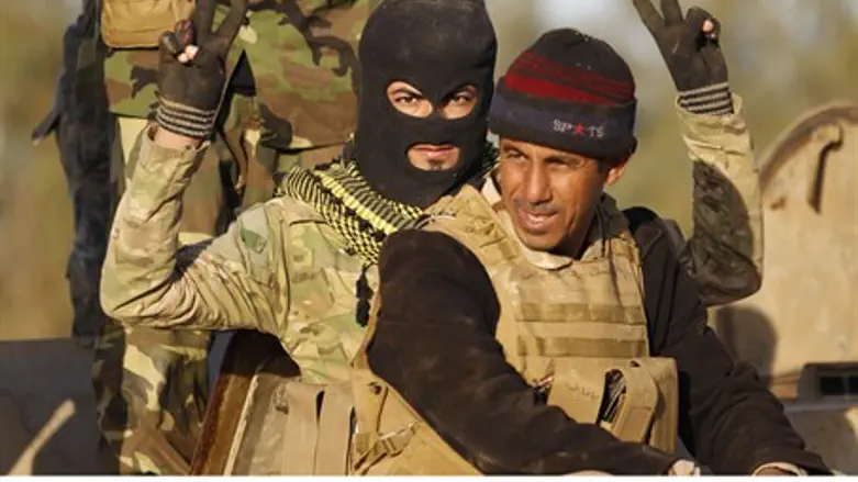 Shia militiamen gesture during clashes with ISIS in Iraq