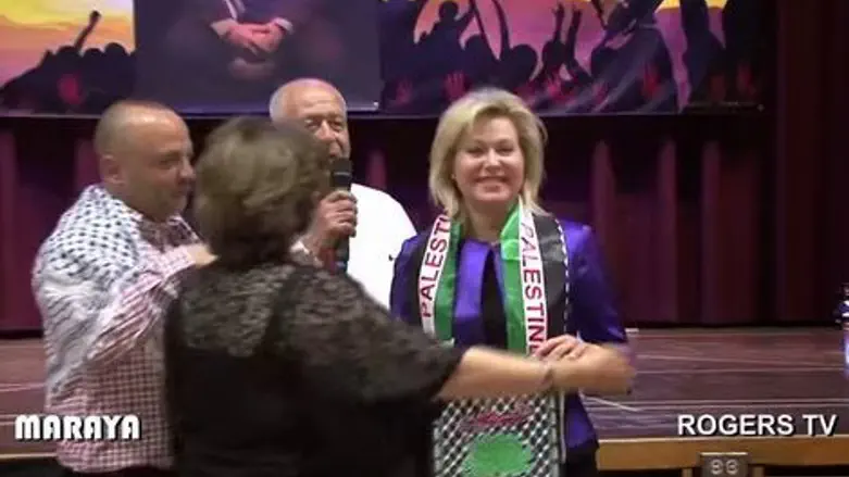 בוני קרומבי עוטה צעיף ועליו דגל פלסטין