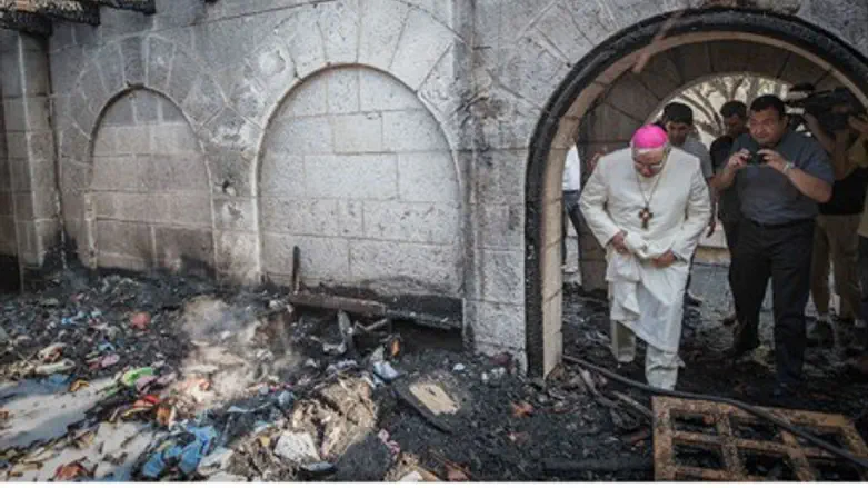A priest inspects the damage at the Church of the Multiplication at Tabgha, on the Sea of