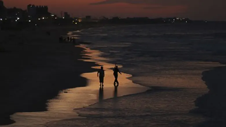 Palestinian Arab fishermen walk along the beach of Gaza City