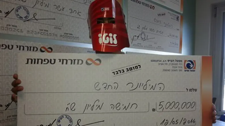 A big lottery winner shows off his check