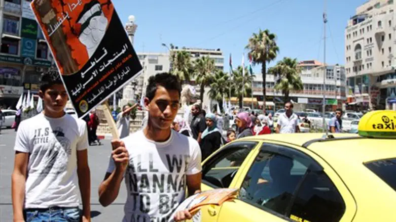 Man waves pro-boycott sign in Ramallah