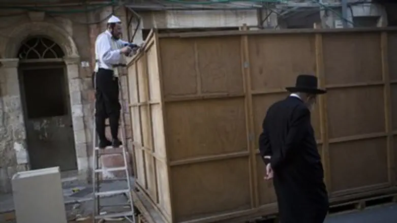 Man building sukkah