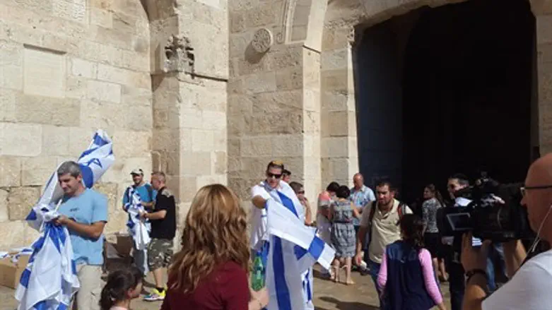 Im Tirzu activists give out flags outside the Jaffa Gate