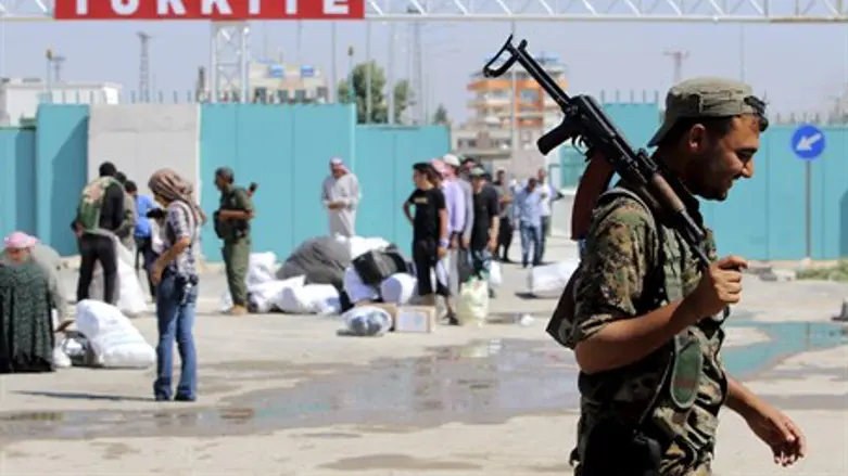 Kurdish YPG fighter walks along Syria-Turkey border