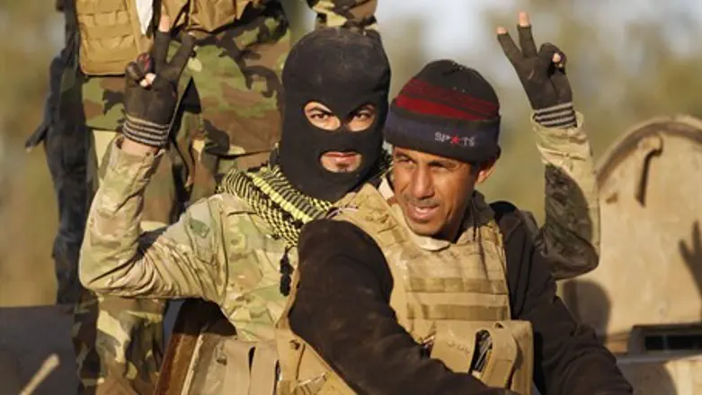 Shia militiamen gesture during clashes with ISIS in Iraq