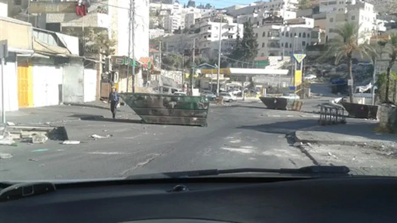 פחים שהובערו חוסמים את הכביש