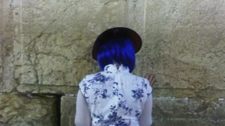 A woman in costume, praying at the Western Wall