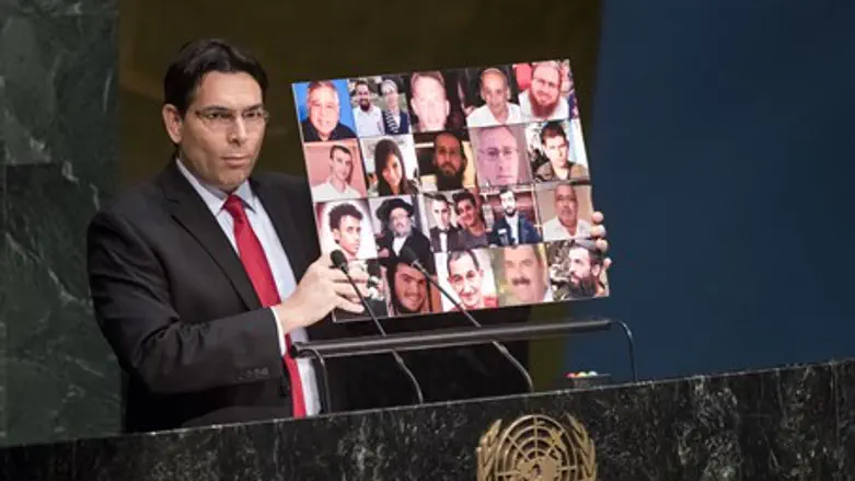 Danon holds up photo of Israeli terror victims (file)