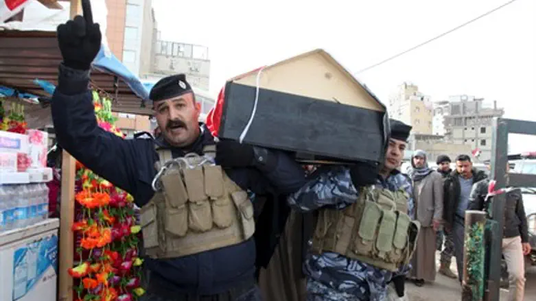 Iraqi soldiers carry body of comrade (file)