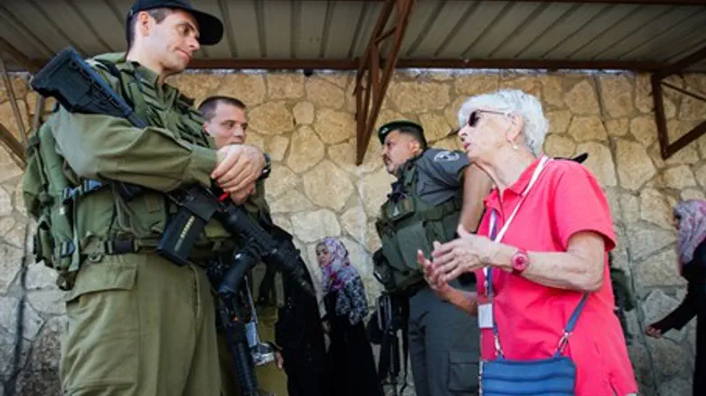 A member of the organization Machsom Watch speaks with border policemen at Checkpoint 300