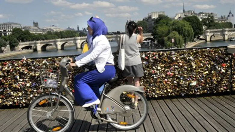 Muslim woman rides a bicycle (illustration)