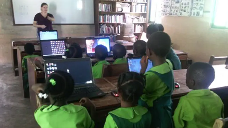 A Project TEN volunteer runs a computer class for children in a fishing village in Ghana