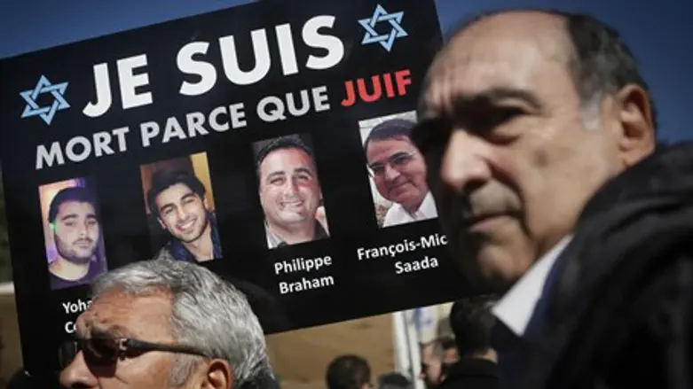 Mourners in Jerusalem hold pictures of Jewish victims of 2015 Paris attacks