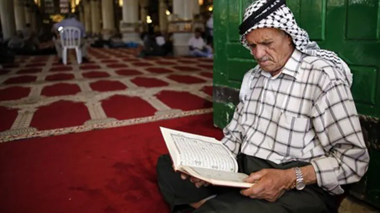 Muslim man reads the Koran during Ramadan at Al Aqsa Mosque
