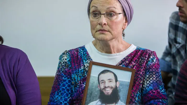 אמו של הרב לביא עם תמונת בנה, בבית המשפט