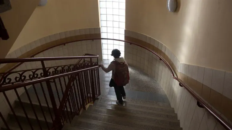 Girl descends stairs in Jerusalem apartment building
