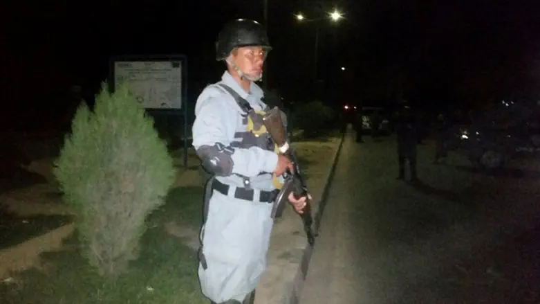 Afghani policeman stands guard outside of American University following terror attack