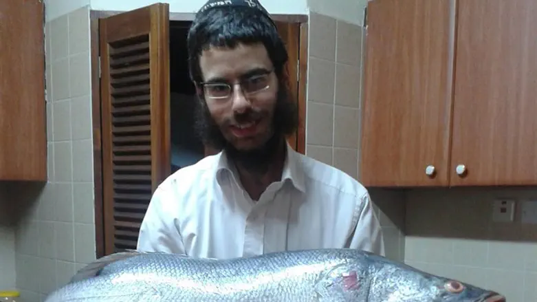 Rabbi Shmuel Notik holding a Nile perch at his home in Nairobi