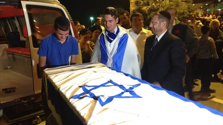 Friends of Ezra Schwartz grieving over his coffin at a service at Ben Gurion Airport