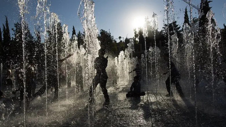 Children play in Jerusalem water fountain on hot day