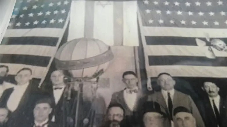 עם דגלי ישראל וארה"ב ברקע. הראי"ה קוק בארה"ב