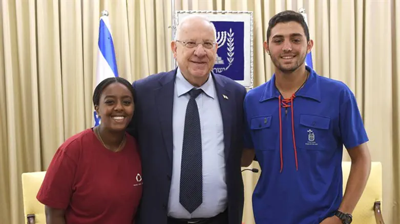 נציג המתנדבים חן חכמי, נשיא המדינה ונציגת המתנדבים בליינש לקאו.