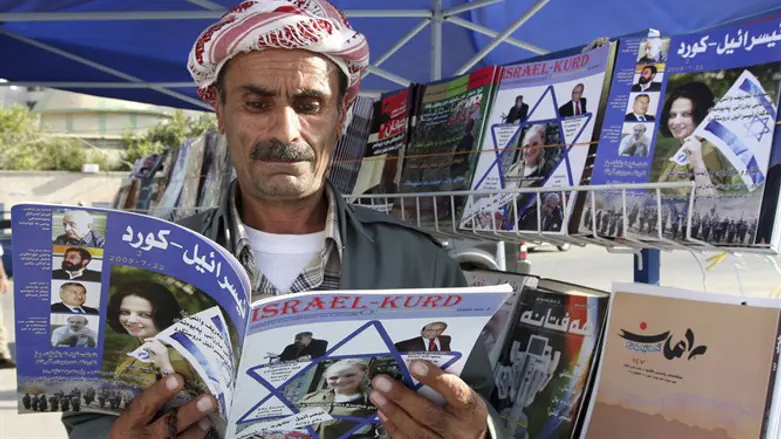 Man reads copy of magazine "Israel-Kurd" at street in Arbil