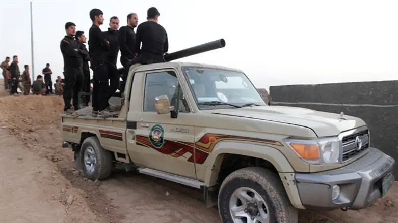 Kurdish Peshmerga fighters ride in vehicle Southwest of Kirkuk