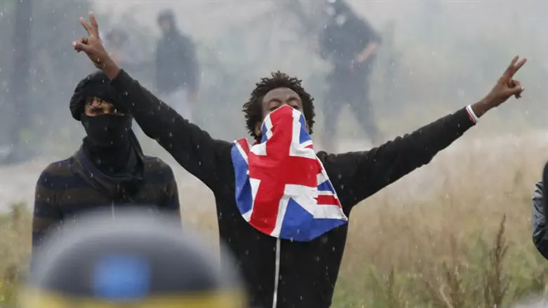 Migrant reacts near French riot police during protest near area known as the "jungle"