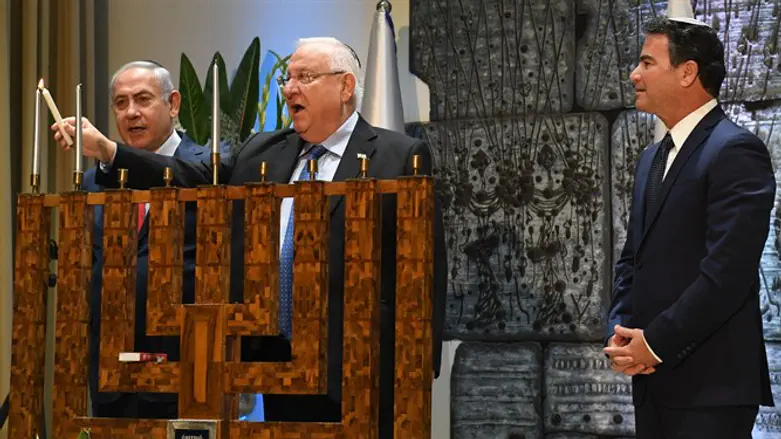 נשיא מדליק נר שני עם ראש הממשלה וראש המוסד, במהלך הטקס
