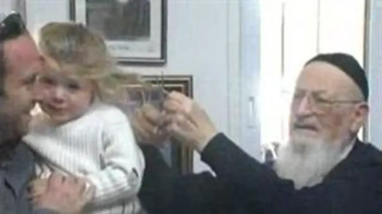 הרב מרדכי אליהו גוזר את שערות הפעוט
