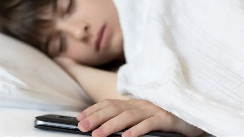 ילד ישן עם סמארטפון. אילוסטרציה