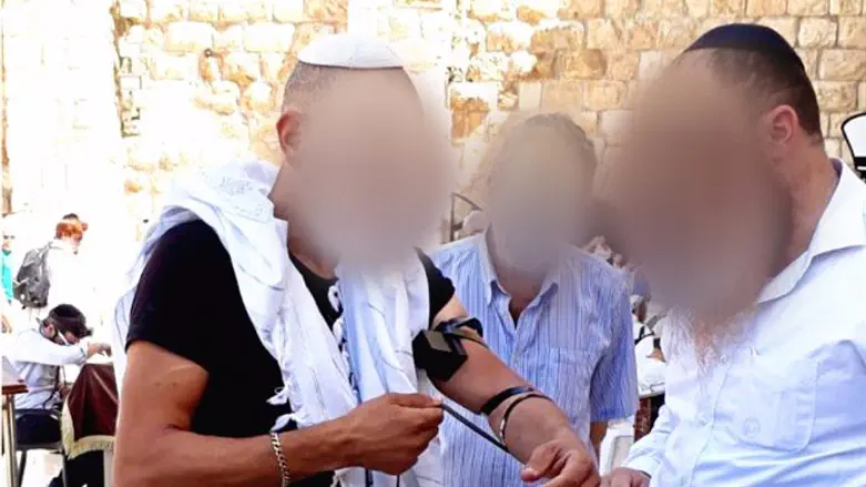 א' מניח תפילין בכותל