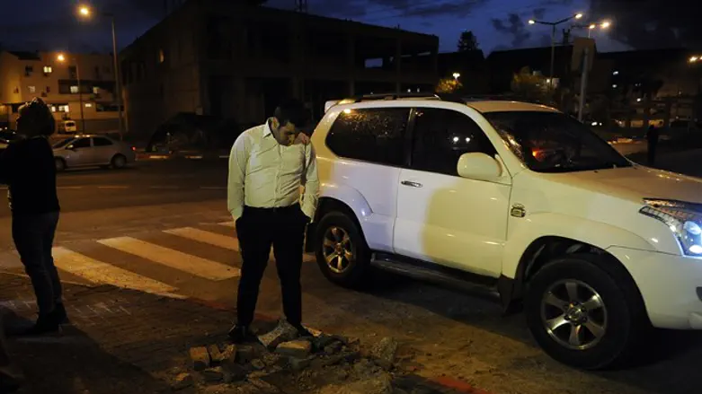 Israeli man inspects the site of Islamic Jihad rocket strike in southern town of Sderot