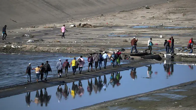 Migrants make their way to border fence in Tijuana