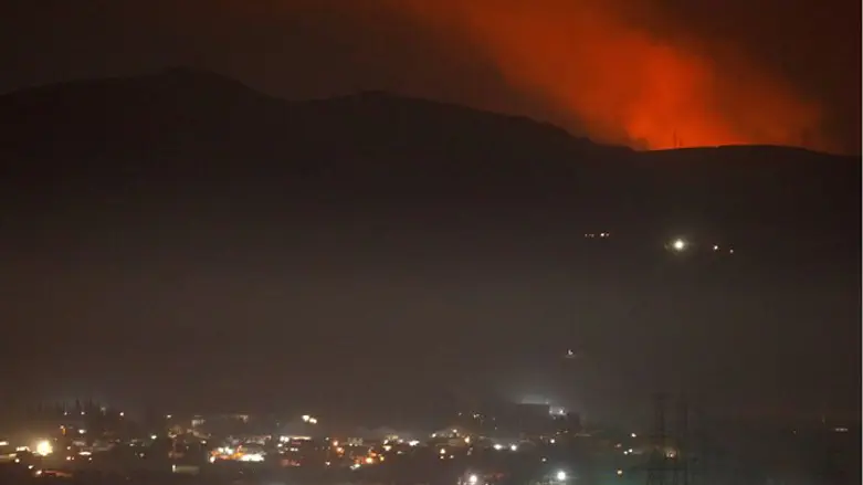 Smoke rises past a mountain as seen from Damascus countryside