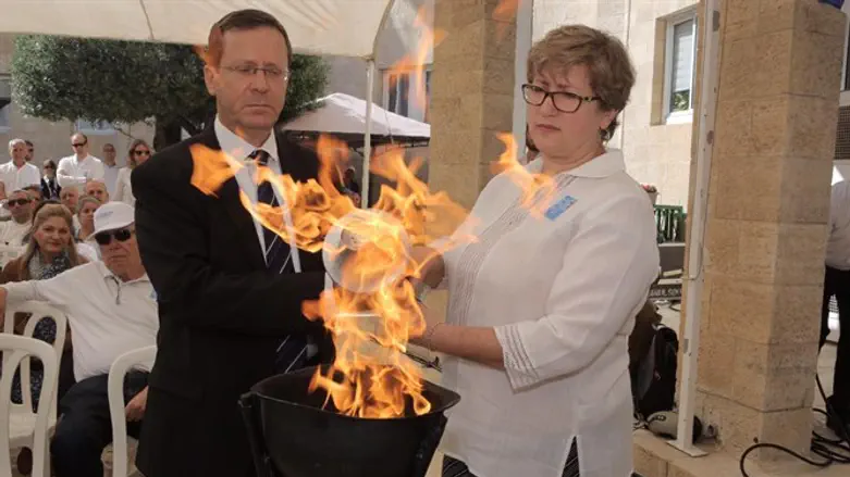 Marnie Fienberg, daughter-in-law of Pittsburgh shooting victim, lights torch with Herzog