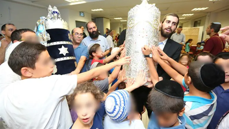 רב בית הכנסת של הזוכה בהגרלה בשנה שעברה רוקד עם ספר התורה