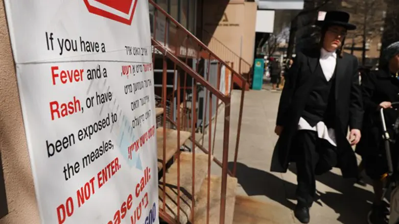 Sign warns people of measles in  Williamsburg, Brooklyn