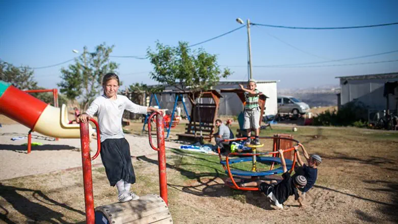ילדים משחקים בגן שעשועים