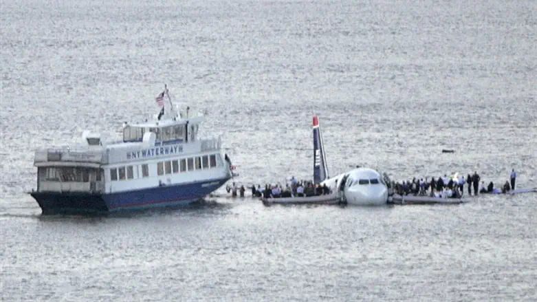 Passengers stand on the wings of a U.S. Airways plane as a ferry pulls up to it