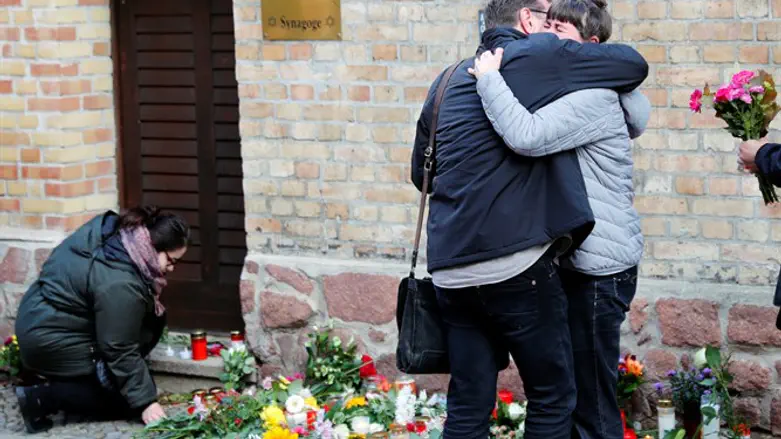 People lay flowers as they mourn outside the synagogue in Halle