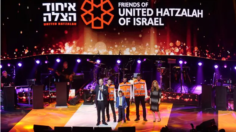 United Hatzalah volunteers on stage with boy they saved and his mother
