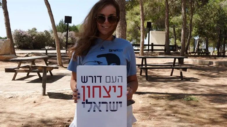 Activist holds up 'The People Demand Victory' sign