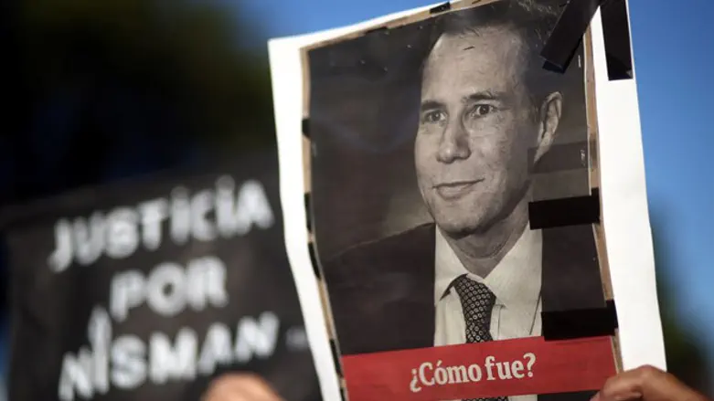 A woman holds up a photo of late state prosecutor Alberto Nisman during commemor